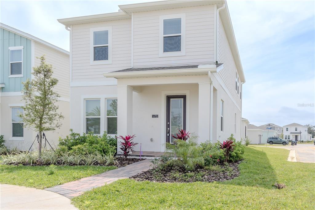 A two-story house with white siding, a covered front porch, and a paved walkway — 16705 VICTORIA GROVE ALLEY, WINTER GARDEN, FL