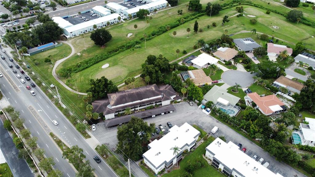 An exterior view of a two-story apartment building next to a grassy lawn and pool — 3606 BENEVA ROAD UNIT 504, SARASOTA, FL