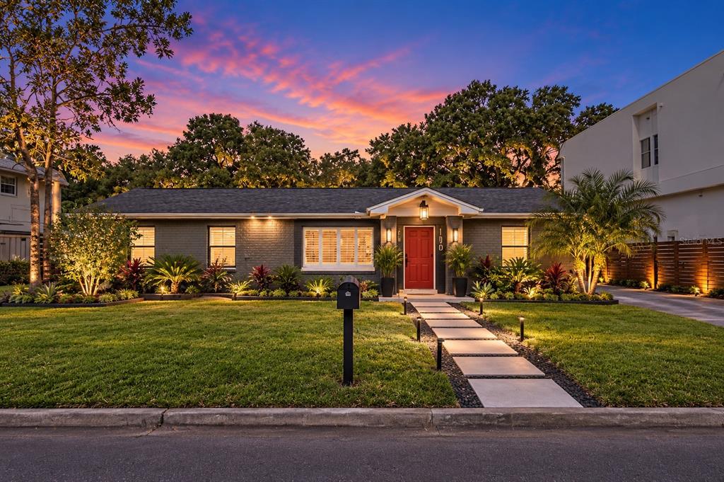 A single-story gray brick house with a red front door and a front lawn — 110 N LINCOLN AVENUE, TAMPA, FL