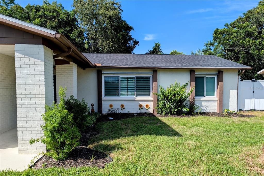 A single-story house with a beige exterior, a two-car garage, and a palm tree — 11608 FOX RUN, PORT RICHEY, FL