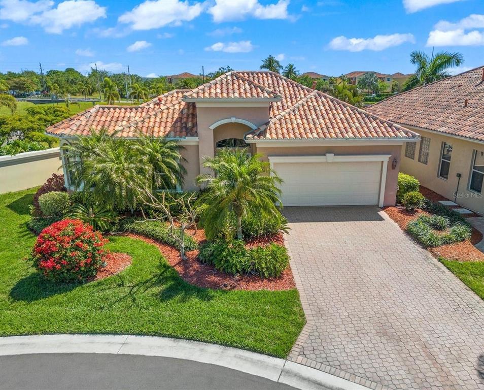 A single-story house with a tile roof, a paved driveway, and landscaped front yard — 312 11TH AVENUE E, PALMETTO, FL