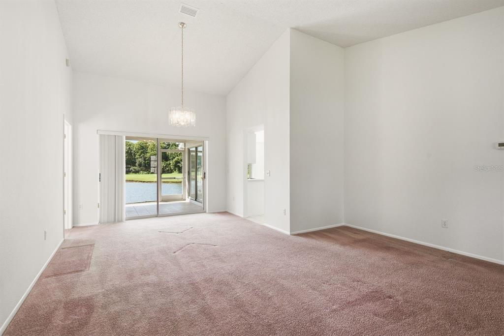 A single-story brick house with a two-car garage sits behind a lawn and large trees — 6639 SUN POINT COURT, NEW PORT RICHEY, FL