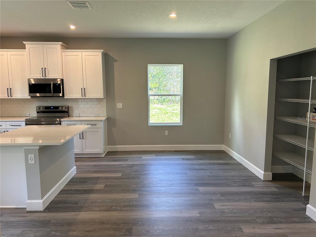 A kitchen with white cabinets, a center island, and a walk-in pantry — 8038 N VOYAGER DRIVE, DUNNELLON, FL