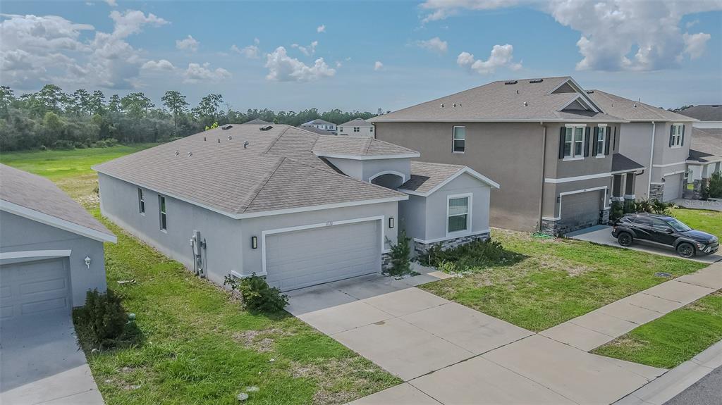 A hallway with light gray walls and tiled flooring leads to a white front door — 11370 TIMBER GROVE LANE, BROOKSVILLE, FL