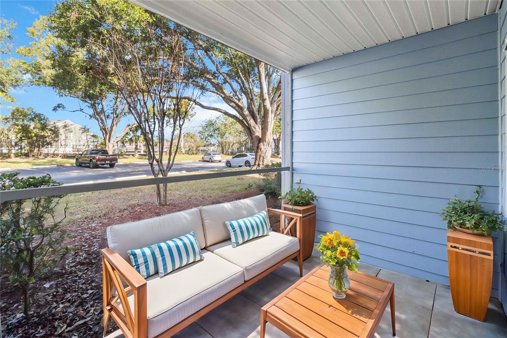 A living room features a beige sofa, two armchairs, a wooden coffee table, and a television — 731 SUGAR BAY WAY UNIT 103, LAKE MARY, FL