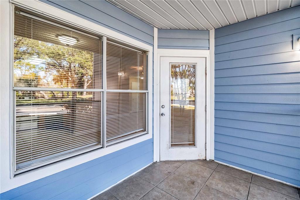 An empty room features light-colored walls, wood-look flooring, a ceiling fan, and a glass-paneled door — 731 SUGAR BAY WAY UNIT 103, LAKE MARY, FL