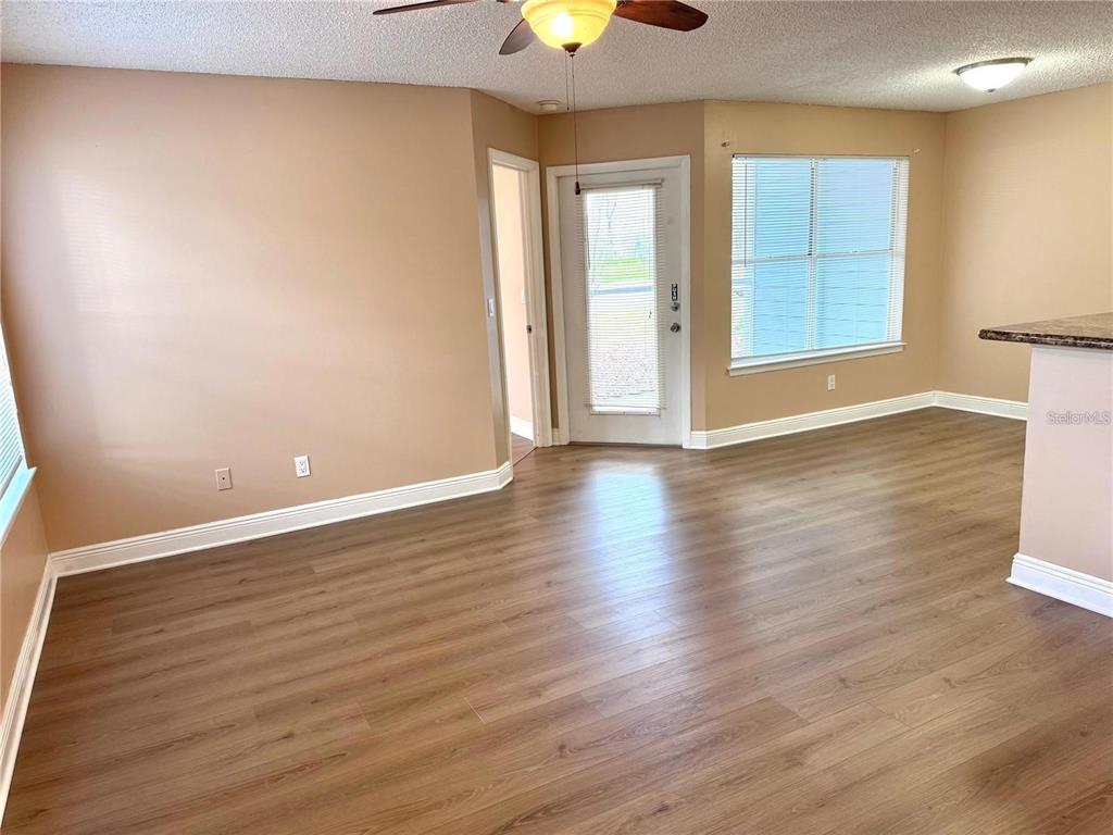 A covered patio with blue horizontal siding, a glass-paneled door, and a large window — 731 SUGAR BAY WAY UNIT 103, LAKE MARY, FL