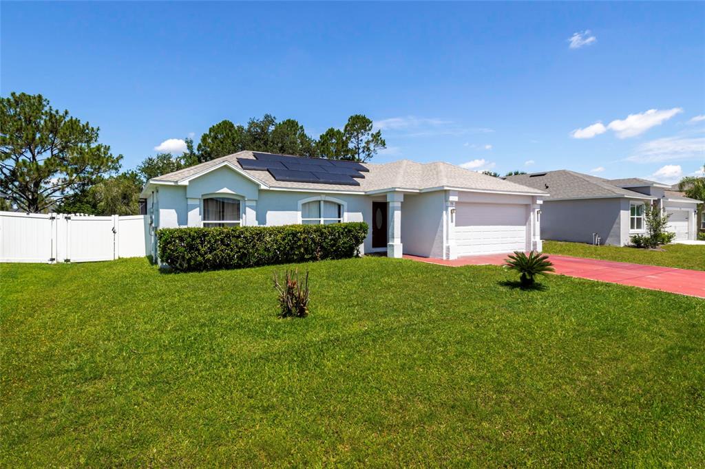 A kitchen features white cabinets, granite countertops, stainless steel appliances, and two hanging pendant lights — 718 TOULON DRIVE, KISSIMMEE, FL