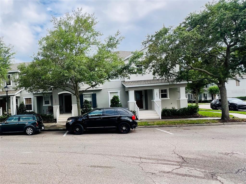 A two-story townhouse exterior with a black SUV parked in front — 13672 CYGNUS DRIVE, ORLANDO, FL