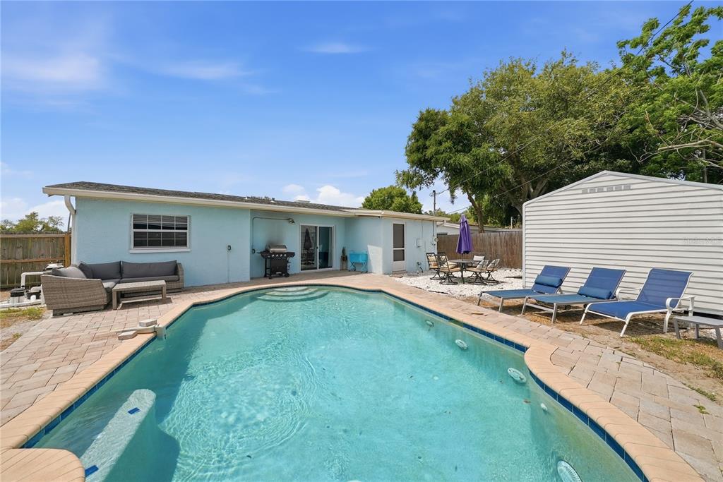 An aerial view shows a light blue house with a driveway and a large front yard — 10437 52ND AVENUE N, ST PETERSBURG, FL