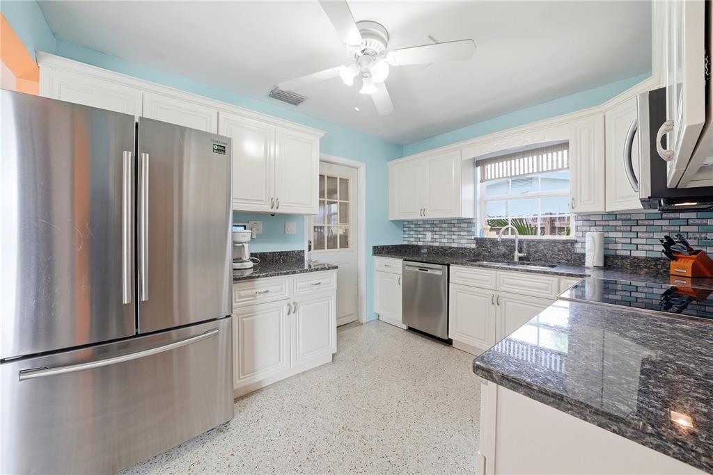 A light blue single-story house features an orange-painted garage door mural and orange window shutters — 10437 52ND AVENUE N, ST PETERSBURG, FL