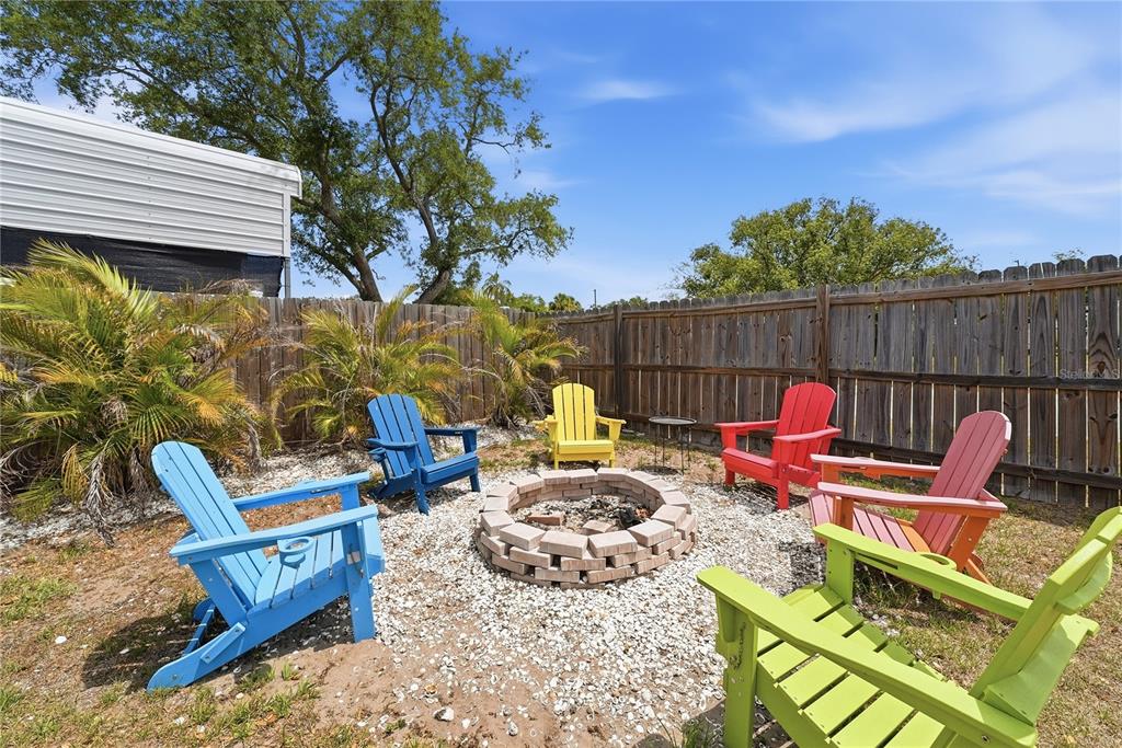 A light blue single-story house with orange shutters, a covered porch, and a gravel driveway — 10437 52ND AVENUE N, ST PETERSBURG, FL