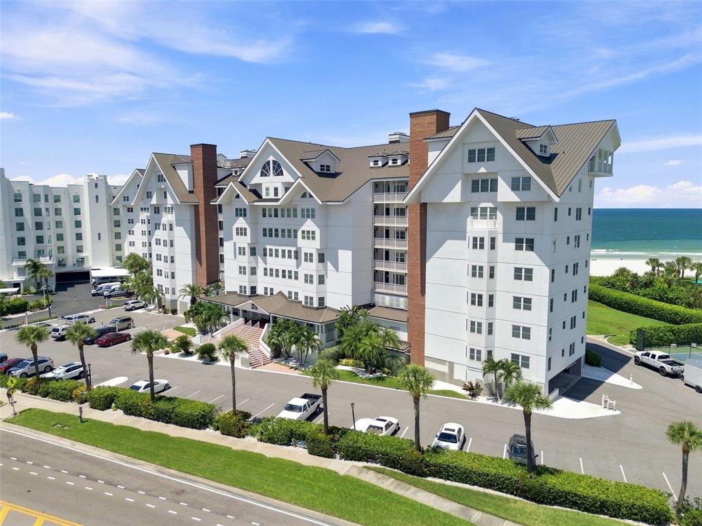 An aerial view of a multi-story white hotel building located next to a sandy beach — 1582 GULF BOULEVARD UNIT 1106, CLEARWATER, FL