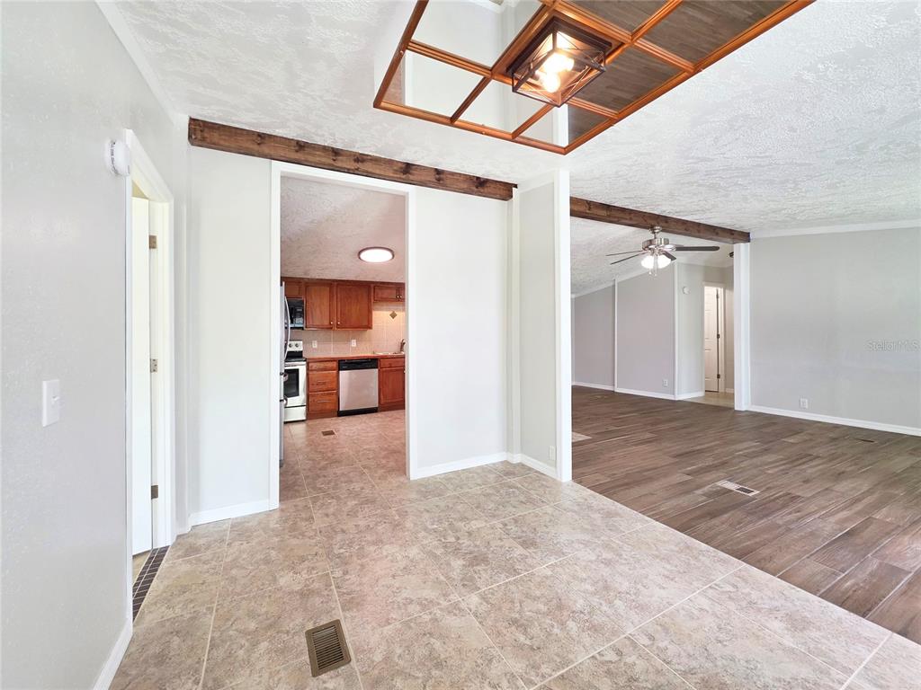 A tiled dining area opens into a kitchen and a living room with wood flooring — 6398 S TROPICANA AVENUE, LECANTO, FL