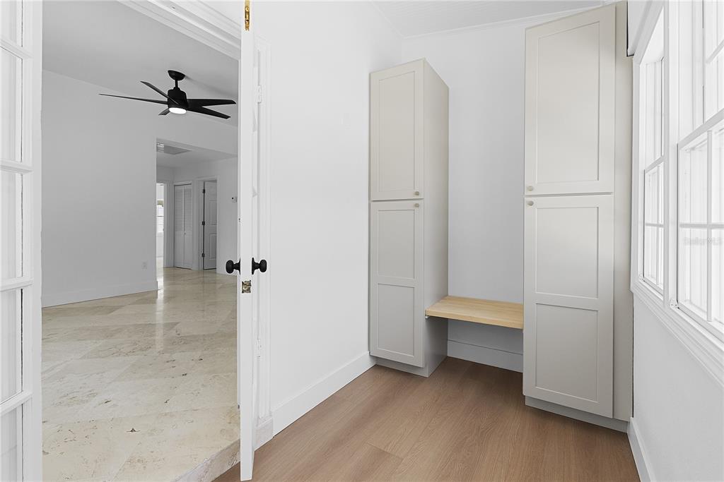A small room features light wood flooring, built-in storage cabinets, and a wooden bench seat — 1313 S DENNING DRIVE, WINTER PARK, FL