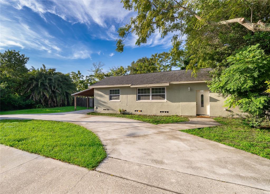 A single-story house with a concrete driveway, a carport, and a light-colored exterior — 324 SEMINOLA BOULEVARD, CASSELBERRY, FL