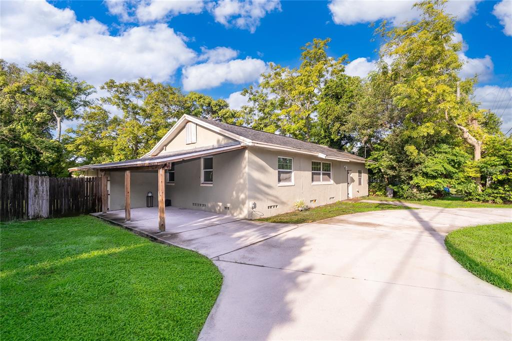 A single-story house with a concrete driveway, a carport, and a wooden fence — 324 SEMINOLA BOULEVARD, CASSELBERRY, FL