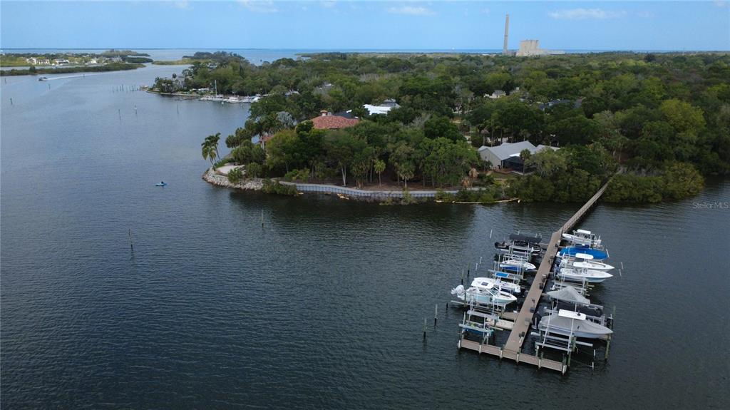 An aerial view shows a large waterfront house with a red-tiled roof and private dock — 1600 MEYERS COVE DRIVE, TARPON SPRINGS, FL