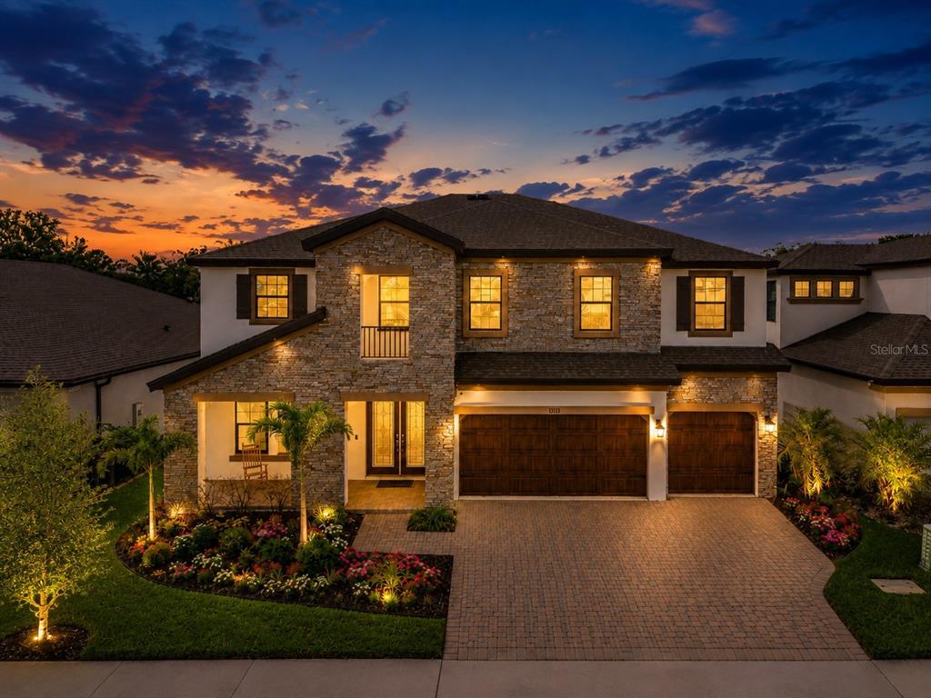 A backyard swimming pool with a spa and stone patio under a blue sky — 13113 WILDFLOWER MEADOW DRIVE, RIVERVIEW, FL