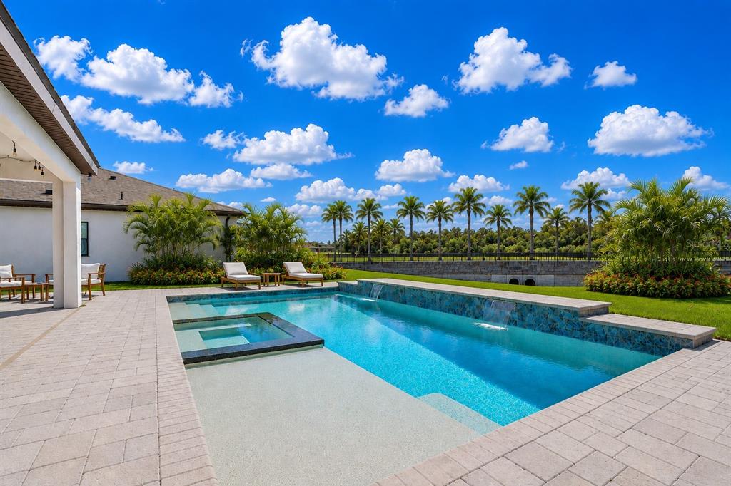 A two-story house exterior features stone veneer, a double front door, and a paved driveway — 13113 WILDFLOWER MEADOW DRIVE, RIVERVIEW, FL