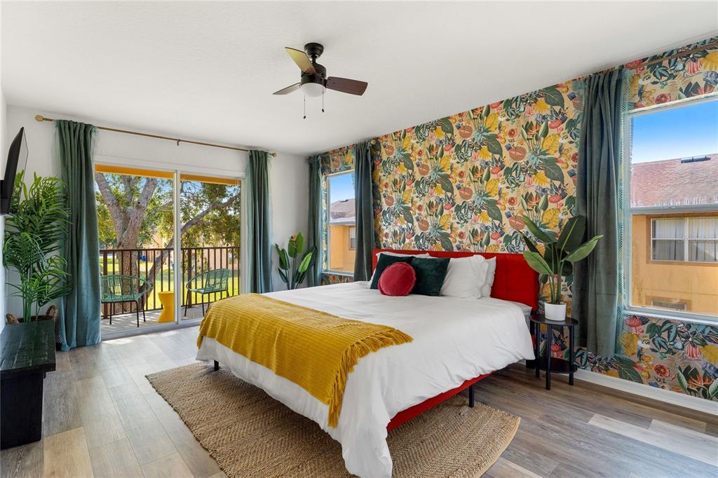 A living room features a houndstooth wingback chair, a yellow sofa, and checkered wallpaper — 2735 CALABRIA AVENUE, DAVENPORT, FL