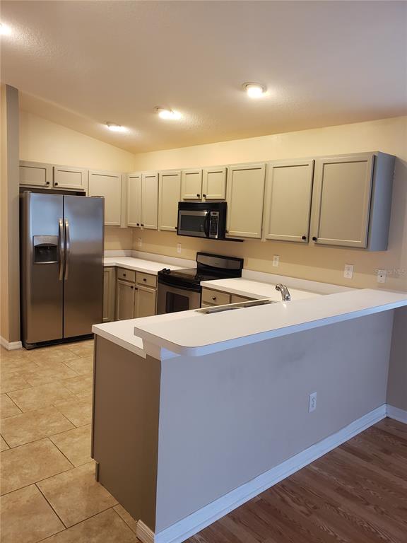 A kitchen with light-colored cabinets, stainless steel appliances, and a breakfast bar — 31316 TRIBOROUGH DRIVE, WESLEY CHAPEL, FL