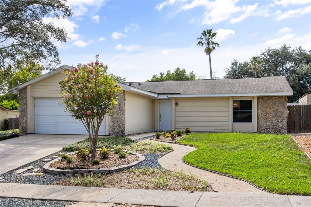 A single-story house with a beige exterior, stone accents, a garage, and a front walkway — 2808 TAMARACK TRAIL, APOPKA, FL
