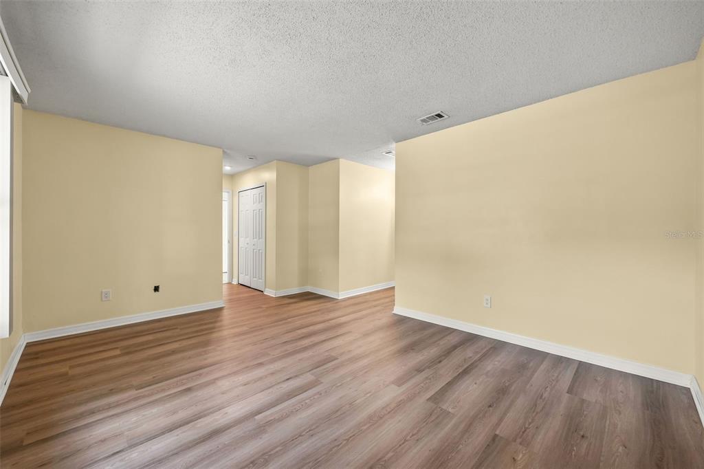 An empty room with light yellow walls and wood-look flooring — 2808 TAMARACK TRAIL, APOPKA, FL