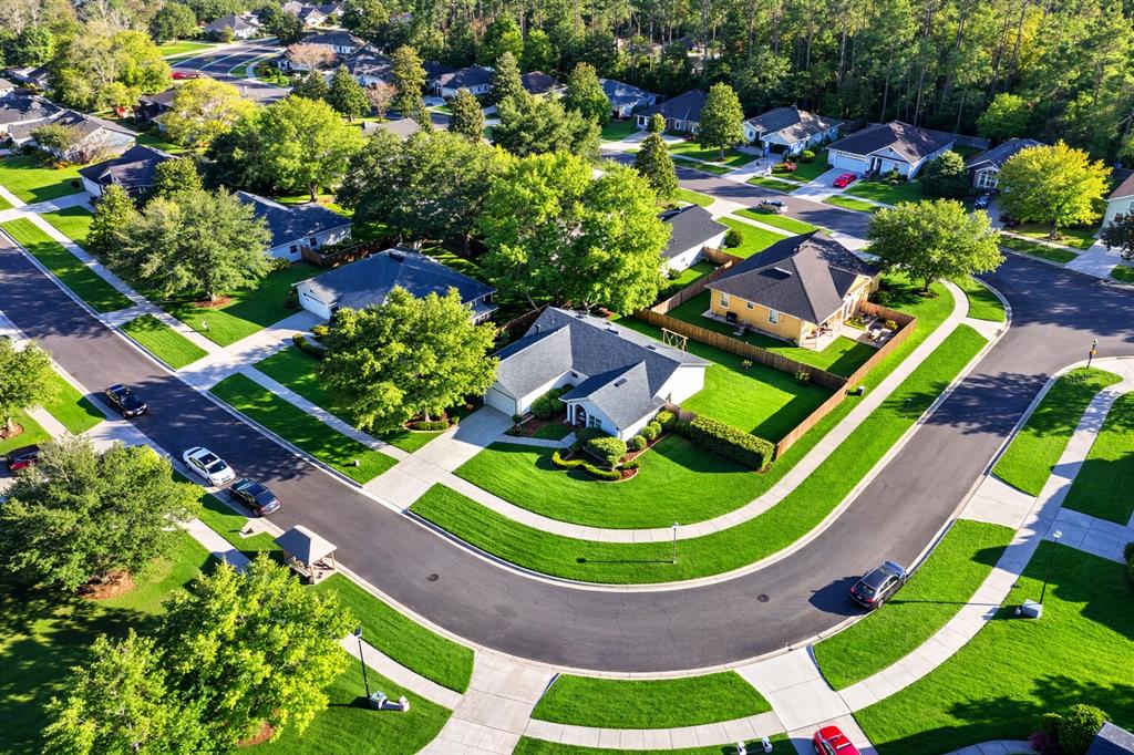 An aerial view shows a suburban neighborhood with single-family homes, green lawns, and paved streets — 14271 NW 10TH ROAD, NEWBERRY, FL