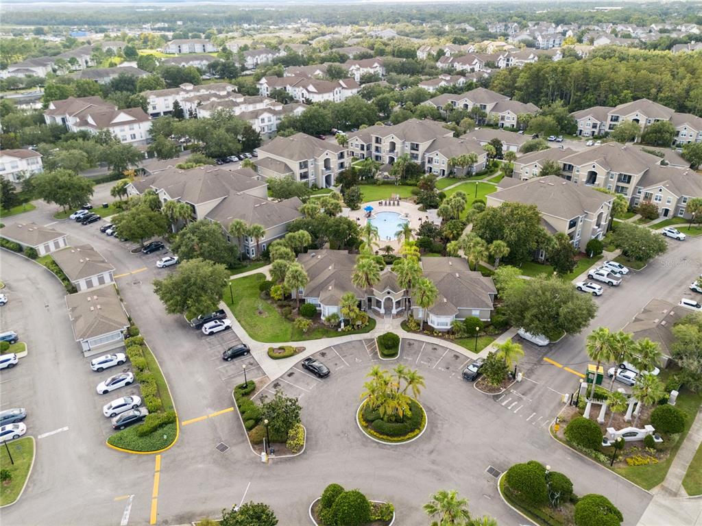 An aerial view shows a multi-building apartment complex with a central pool and parking lots — 6596 SWISSCO DRIVE UNIT 1512, ORLANDO, FL