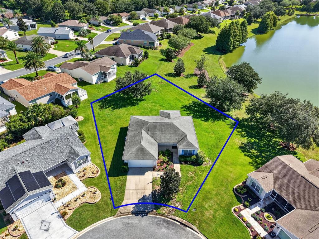 An aerial view shows a single-story house with a large yard outlined in blue — 2112 KERWOOD LOOP, THE VILLAGES, FL