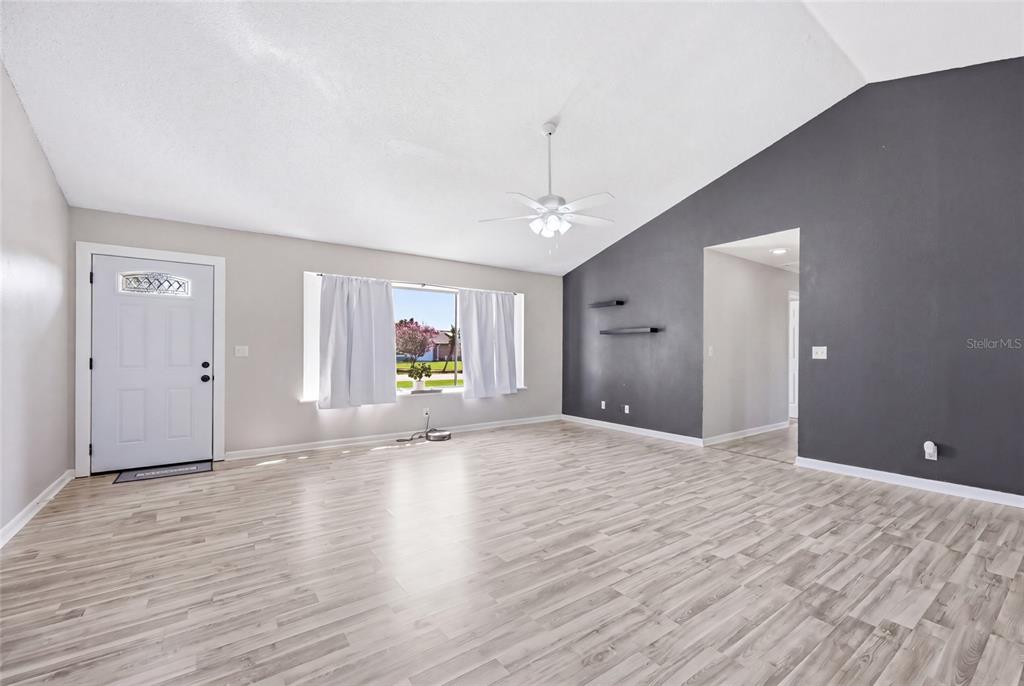 A red front door is set in a white stucco wall beside a brick chimney — 2643 SALTERS COURT, DELTONA, FL