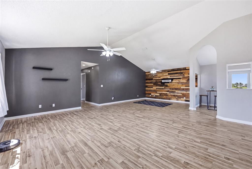 A bright entryway features light gray walls, wood-look flooring, a white front door, and windows — 2643 SALTERS COURT, DELTONA, FL