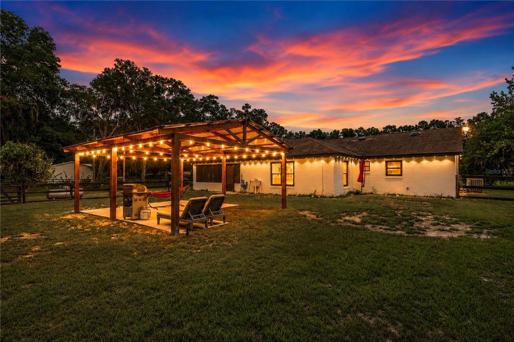 An aerial view shows a house situated on a large, tree-lined, fenced-in grassy lot — 2735 NE 127TH PLACE, ANTHONY, FL