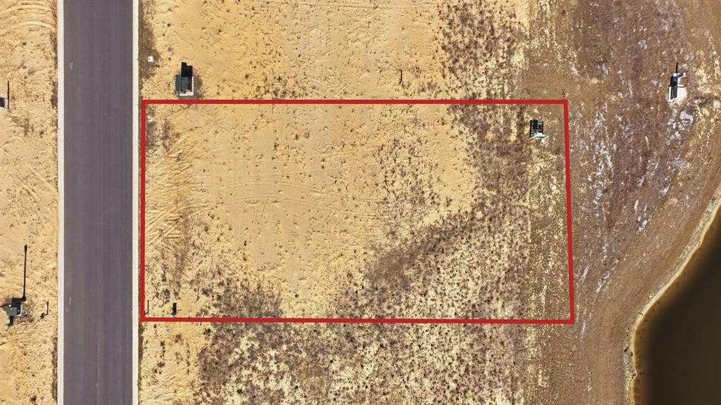 An aerial view shows a rectangular vacant residential lot outlined in red next to a road — 200 STILLWATER DRIVE, FLAGLER BEACH, FL