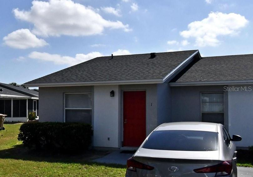 A silver sedan is parked in front of a gray house with a red door — 1 LAKE VILLA WAY, KISSIMMEE, FL