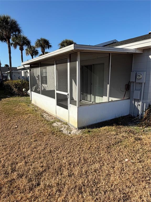 A white screened-in porch is attached to the side of a residential building — 1 LAKE VILLA WAY, KISSIMMEE, FL