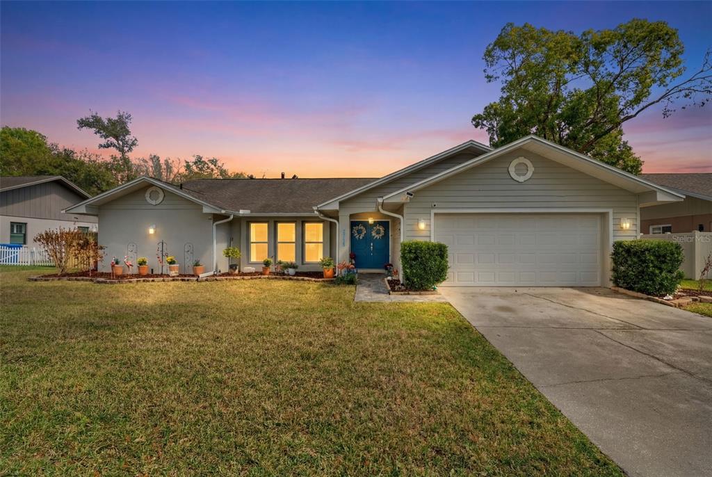A single-story house with light siding, a blue front door, and a two-car garage — 2715 BERRYKNOLL PLACE, VALRICO, FL