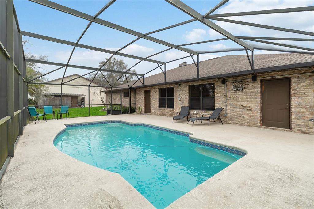 A brick house and a detached garage sit on a large lawn at sunset — 18711 NORTHCLIFF STREET, ORLANDO, FL