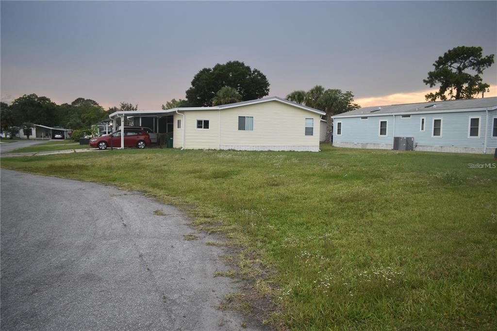 A yellow mobile home and a light blue mobile home sit on a grassy lot — LOT 8 BLK D LEXINGTON CIRCLE, WILDWOOD, FL