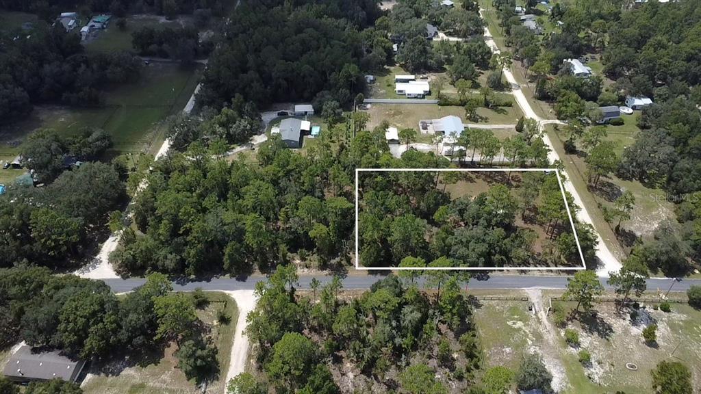 An aerial view shows a rectangular plot of land outlined in white among wooded surroundings — 2851 SE 143RD TERRACE, MORRISTON, FL