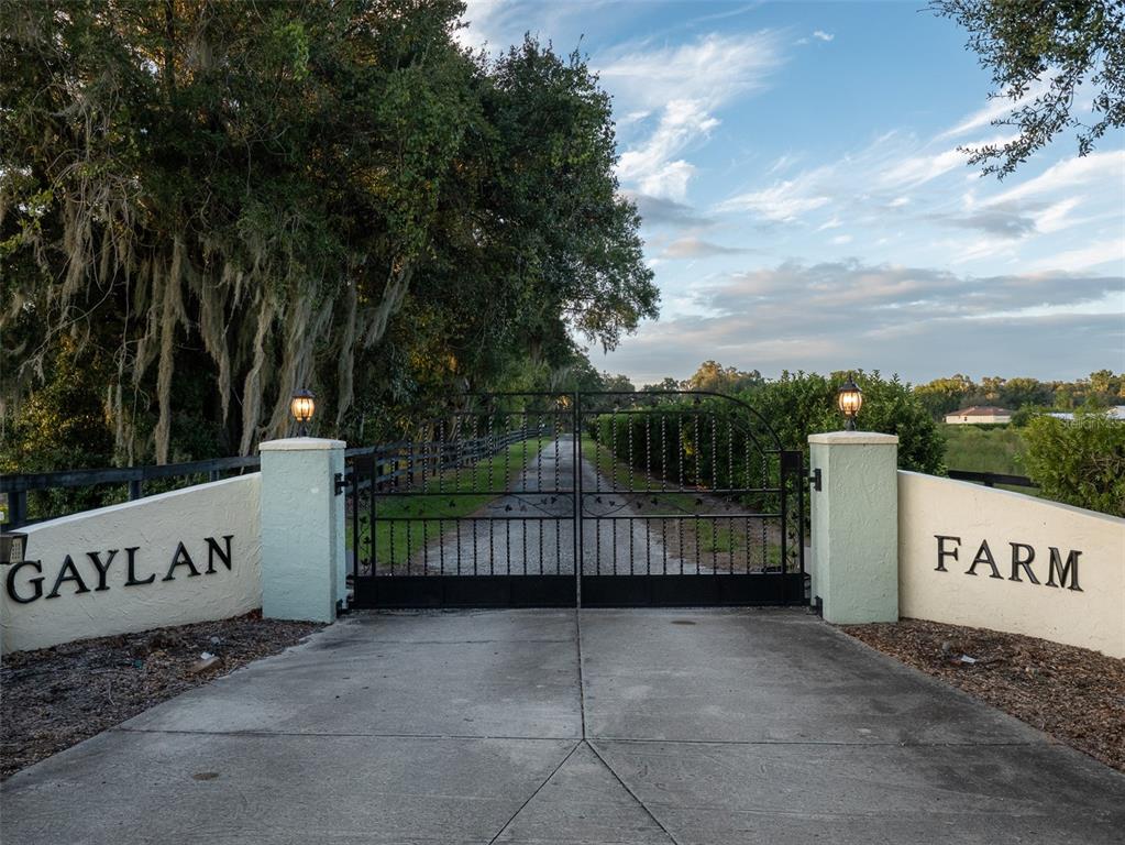 A gated entrance with a paved driveway leads to a property labeled Gaylan Farm — 9481 W HIGHWAY 316, REDDICK, FL