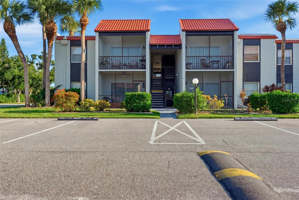 A two-story apartment building with a red tile roof and screened balconies — 3267 BENEVA ROAD UNIT 203, SARASOTA, FL