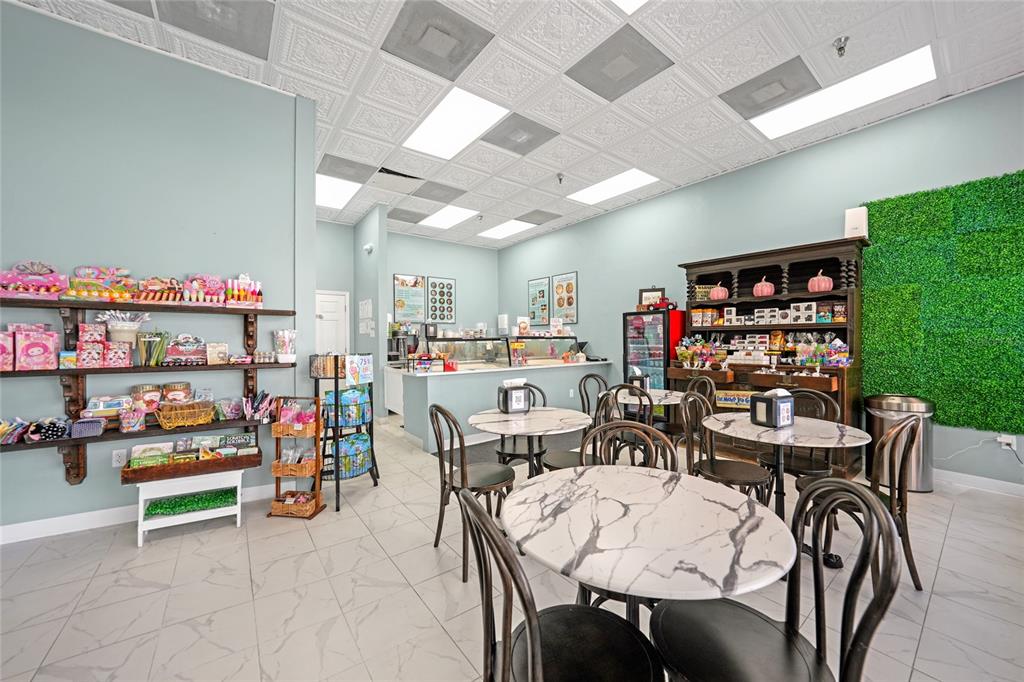 A commercial space features marble-topped tables, wooden shelving, and a green wall accent — 203 W OAK STREET, ARCADIA, FL