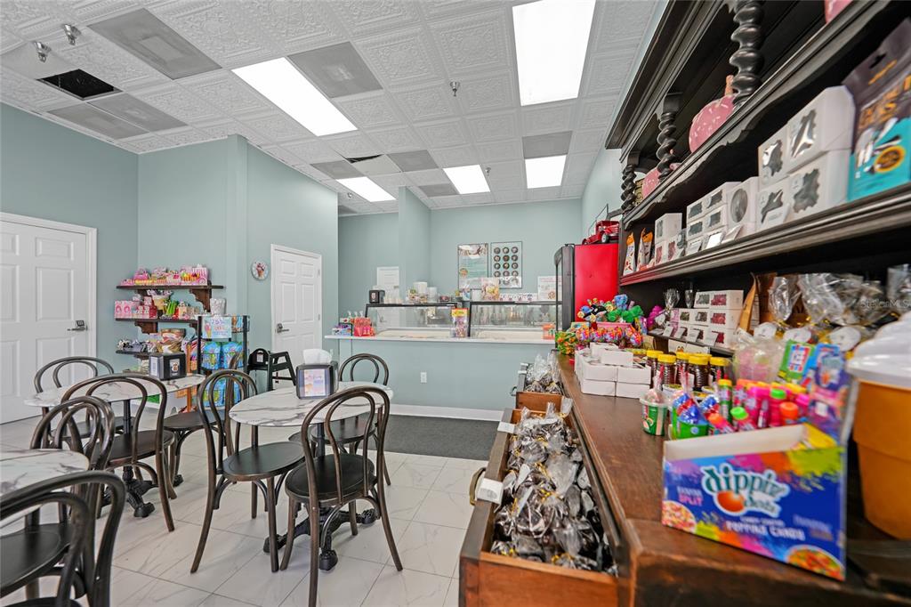 This ice cream shop features tables, chairs, a service counter, and shelves stocked with candy — 203 W OAK STREET, ARCADIA, FL