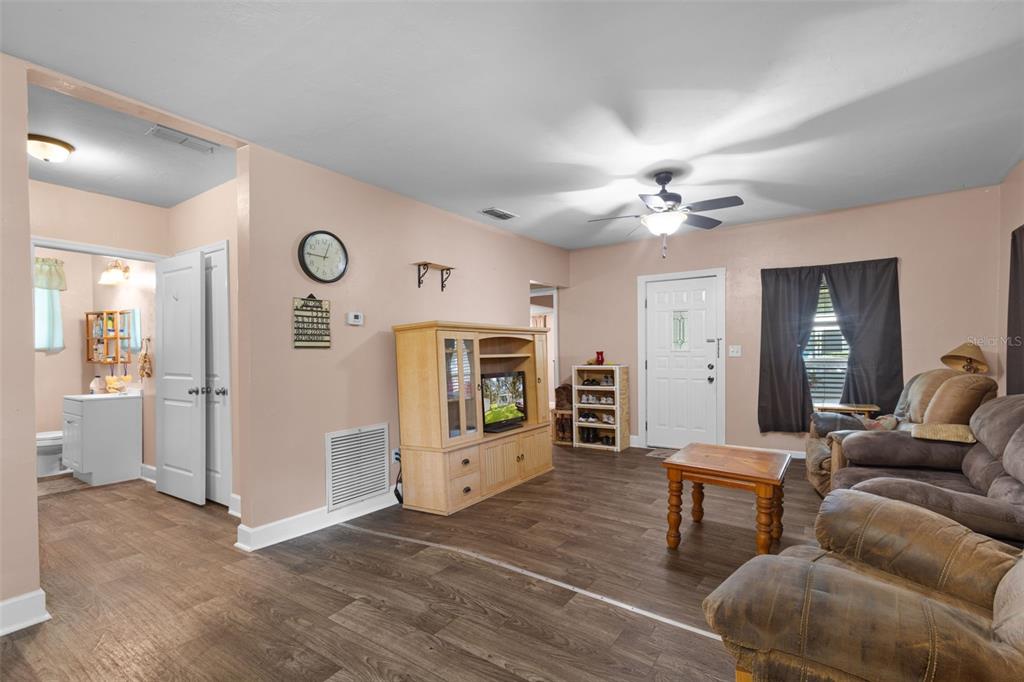 A living room with light pink walls, wood-look flooring, a ceiling fan, and brown furniture — 729 NW 3RD AVENUE, TRENTON, FL