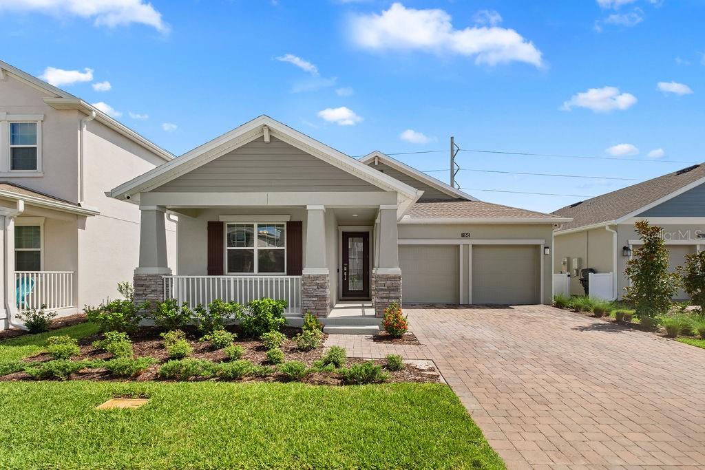 A single-story house features a covered front porch, a two-car garage, and a paved driveway — 11843 LANGUAGE WAY, ORLANDO, FL