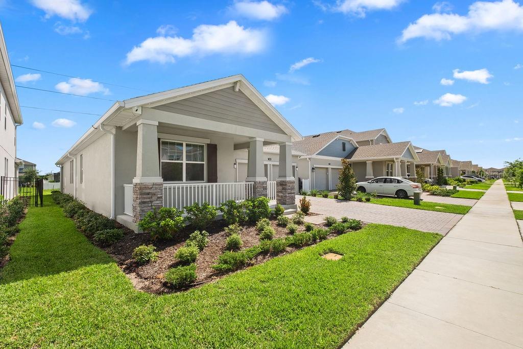A single-story house with a front porch, stone accents, and a paved driveway — 11843 LANGUAGE WAY, ORLANDO, FL