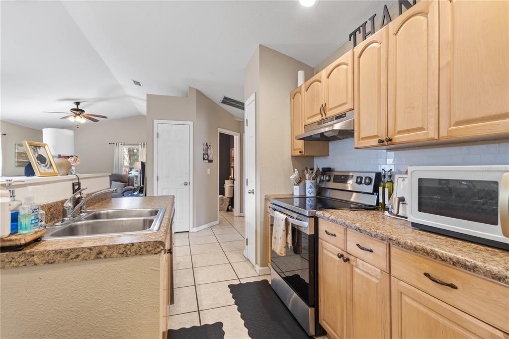 A living room features a brown sectional sofa, a round coffee table, and a television — 308 SW 2ND AVENUE, CHIEFLAND, FL
