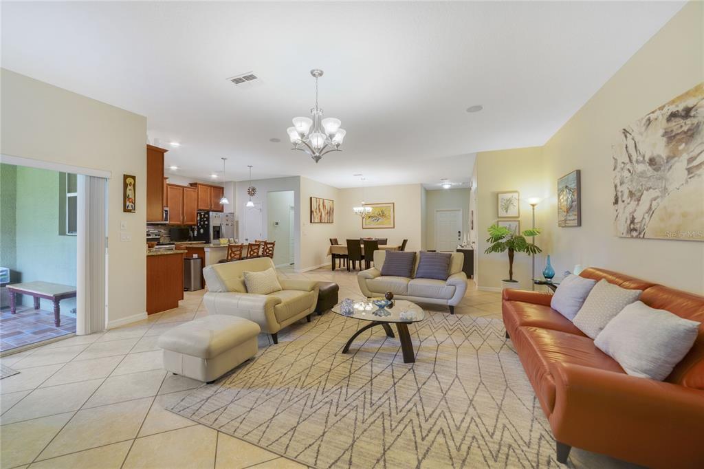 An open-concept living and dining area features tile flooring, a kitchen, and neutral walls — 3349 RODRICK CIRCLE, ORLANDO, FL